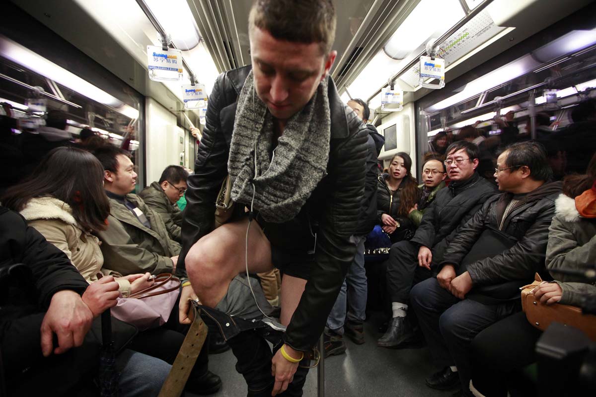 Passengers react to seeing a man take off his pants on the subway during th...