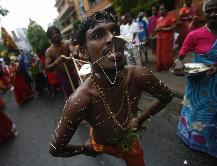 A devotee takes part during in the annual Chariot festival of the Sri Mayurapathy Paththirakaali temple in Colombo. The chariot procession starts at the temple and is brought through streets as Hindu devotees follow behind, performing acts of penance or thanksgiving such as piercing hooks through their skin, in order to fulfill their vows to the Hindu gods. (Dinuka Liyanawatte/Reuters)