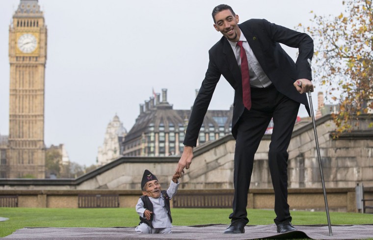 Chandra Bahadur Dangi, from Nepal, (L) the shortest adult to have ever been verified by Guinness World Records, poses for pictures with the world's tallest man Sultan Kosen from Turkey, during a photocall in London on November 13, 2014, to mark Guinness World Records Day. Chandra Dangi, measures a tiny 21.5in (0.54m) the same height as six stacked cans of beans. Sultan Kosen measures 8 ft 3in (2.51m). (Andrew Cowie/AFP/Getty Images)