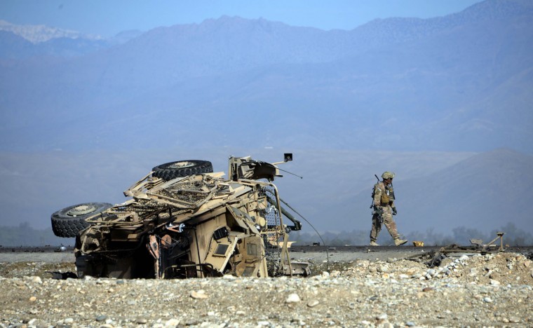 A US soldiers inspects the site of a suicide attack targeting foreign troops in Jalalabad on November 13, 2014. A suicide bomber rammed his explosive-laden vehicle into an armoured vehicle of foreign forces in Jalalabad, the capital of eastern Nangarhar province on November 13, officials said. The attack caused no fatalities to foreign forces or civilians, but damaged an armoured vehicle. (Noorullah Shirzada/AFP/Getty Images)