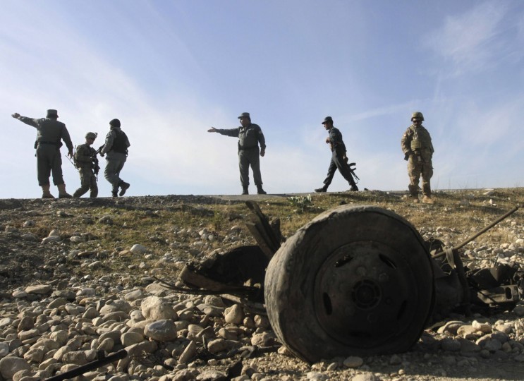 U.S. troops and Afghan policemen inspect at the site of a suicide attack on the outskirts of Jalalabad, November 13, 2014. The suicide bomber rammed his explosive-laden vehicle into U.S. forces travelling in a NATO convoy on Thursday in eastern Nangarhar province; the attack caused no fatalities to foreign forces or civilians, but damaged an armoured vehicle, the provincial spokesman Ahmadzia Abdulzai said, local media reported.(Parwiz/Reuters)