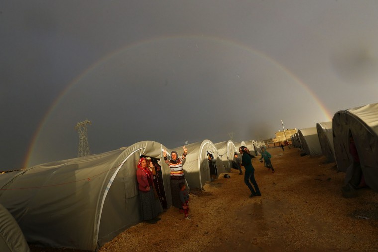 A Kurdish refugee from the Syrian town of Kobani shows victory sign as a rainbow forms over the camp in the southeastern town of Suruc, Sanliurfa province, in this October 16, 2014 file photo. Reuters photographers have chronicled Kurdish refugee crises over the years. In 1991 Srdjan Zivulovic documented refugees in Cukurca who had escaped a military operation by Saddam Hussein's government in Iraq aimed at "Arabising" Kurdish areas in the north. Hundreds of thousands fled into Turkey and Iran. Images shot in recent months show familiar scenes as crowds of people flee Islamic State militants in Syria. There are as many as 30 million Kurds, spread through Turkey, Iraq, Syria and Iran. Most Kurds are Sunni Muslims, but tend to feel more loyalty to their Kurdishness, rather than their religion. (Kai Pfaffenbach/Files/Reuters)