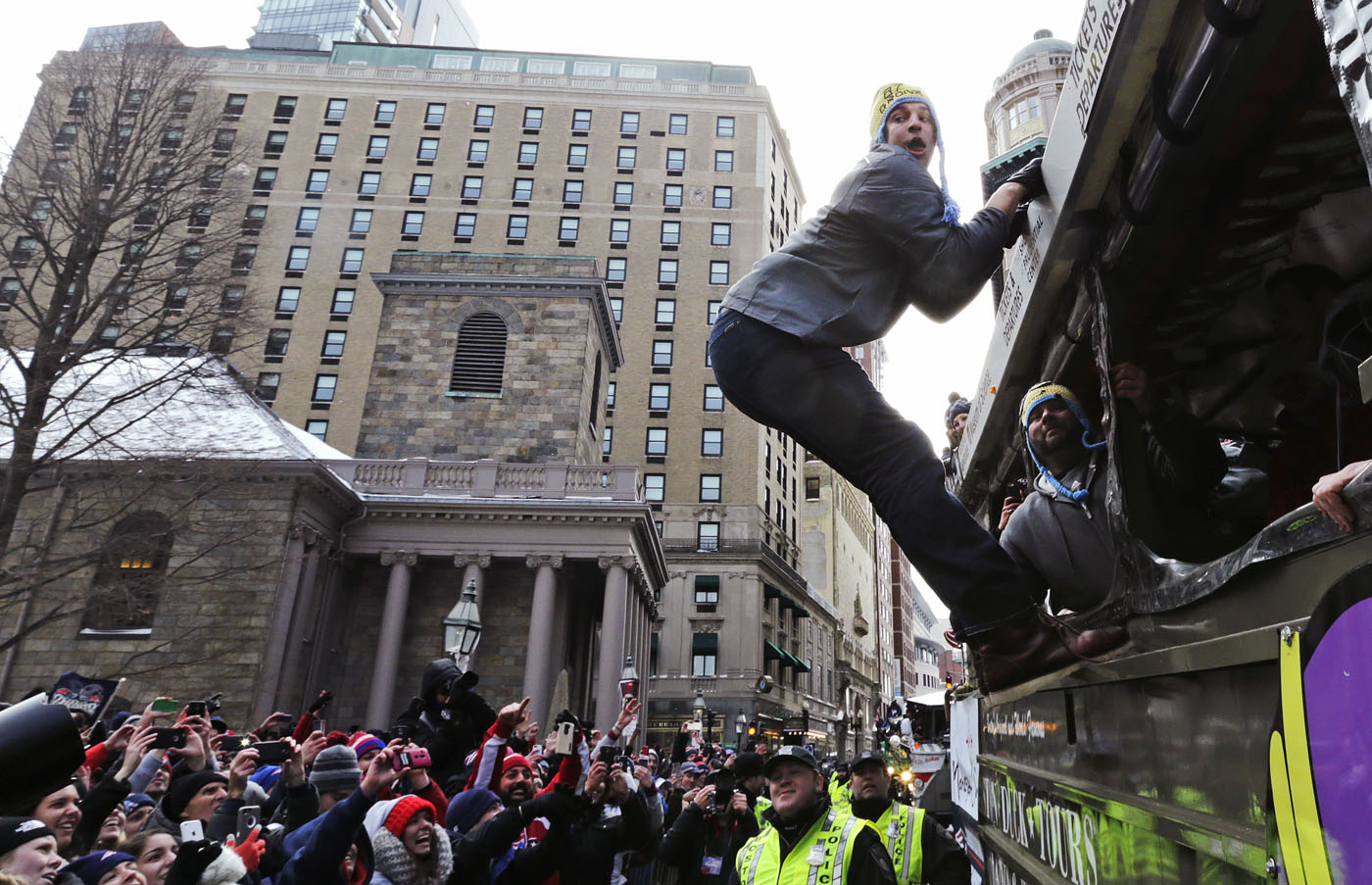 hangs out of a duck boat as fans cheer during a parade in Boston 