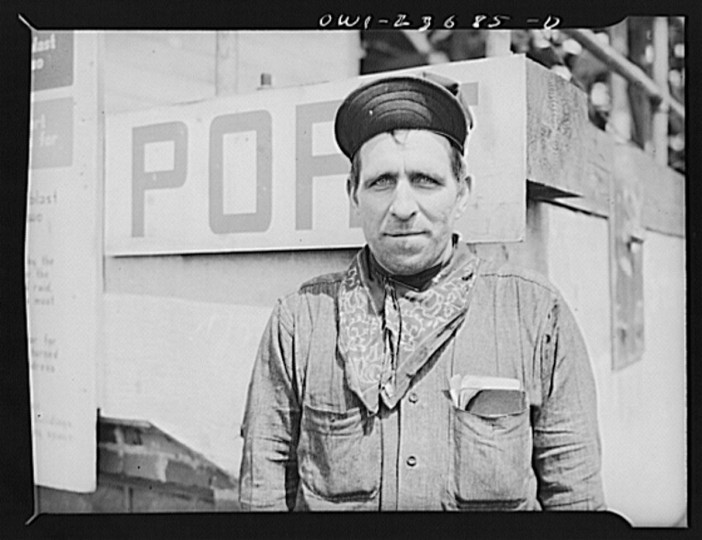 Bethlehem-Fairfield shipyards, Baltimore, Maryland. Worker in front of a port sign on the shipways. (Arthur S. Siegel / May 1943)