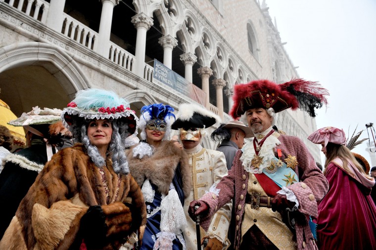 Masked people pose in Venice, Italy, Sunday, Jan. 31, 2016. People attended the Venice Carnival, celebrated Saturday under heightened security following the sexual assaults on New Year's Eve in Cologne and the ongoing terror threat in Europe. Authorities have increased surveillance throughout the city, including the number of officers on patrol, both under-cover and in uniform. (AP Photo/Luigi Costantini)