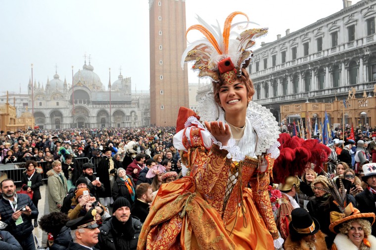 Irene Rizzi blows a kiss after descending from the bell tower into St. Mark's Square, in Venice, Sunday, Jan. 31, 2016. Carnival-goers in Venice are being asked by police to momentarily lift their masks as part of new anti-terrorism measures for the annual festivities. Sunday's main crowd-pleaser known as the Flight of the Angel went off without a hitch. In that event, a costumed young woman, attached by wires, " flies " over the crowd, starting from St. Mark's bell tower and gradually descending to the square. (AP Photo/Luigi Costantini)