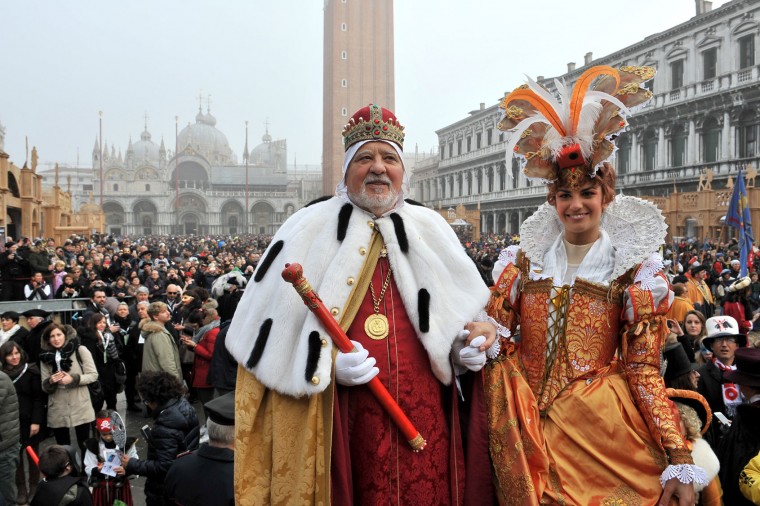 Irene Rizzi, right, poses with a man impersonating the Doge of Venice after descending from the bell tower into St. Mark's Square, in Venice, Sunday, Jan. 31, 2016. Carnival-goers in Venice are being asked by police to momentarily lift their masks as part of new anti-terrorism measures for the annual festivities. Sunday's main crowd-pleaser known as the Flight of the Angel went off without a hitch. In that event, a costumed young woman, attached by wires, " flies " over the crowd, starting from St. Mark's bell tower and gradually descending to the square. (AP Photo/Luigi Costantini)