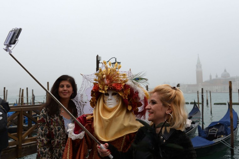 Costumed reveller poses for selfie in St Mark's square (Piazza San Marco) after the officially launch of the Venice Carnival on January 31, 2016 in Venice. The 2016 edition of the Venice carnival is untitled "Creatum" and runs until February 9th. (Vincenzo Pinto/AFP/Getty Images)