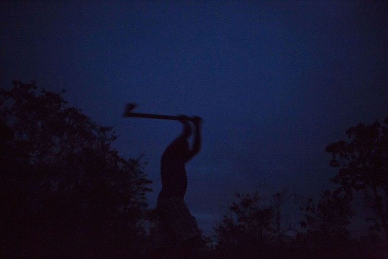 In this Nov. 13, 2015 photo, an artisanal diamond miner chops firewood in Areinha, Minas Gerais state, Brazil. The area has been explored for the precious stone since the time of slavery. (AP Photo/Felipe Dana)