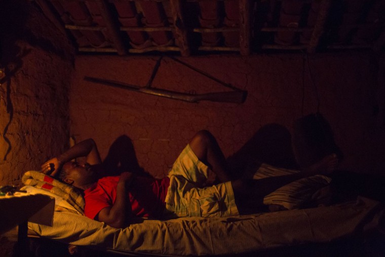 In this Nov. 15, 2015 photo, Jose Vanderson rests on his bed in Areinha, Minas Gerais state, Brazil. Born and raised in Areinha, Vanderson says diamond mining is part of the culture of this region, where the first stone was found nearly 300 years ago. (AP Photo/Felipe Dana)