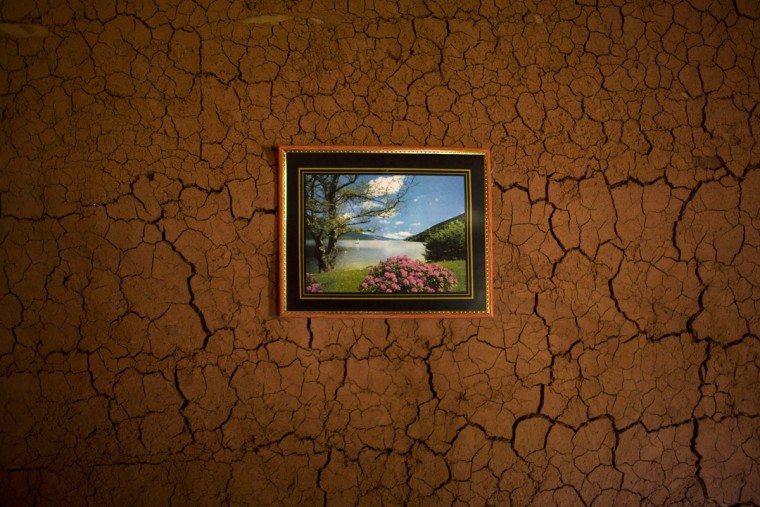 In this Nov. 13, 2015 photo, a picture hangs on the wall inside an artisanal diamond miner's home in Areinha, Minas Gerais state, Brazil. The devastated area abandoned by giant mining corporations is now a no man's land where small groups of rural workers try their luck with manual techniques and little to no infrastructure. (AP Photo/Felipe Dana)