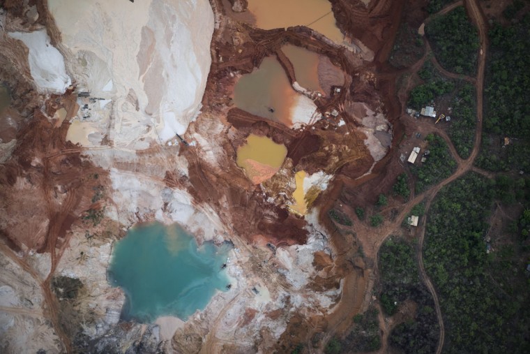 This Nov. 18, 2015 photo shows an area that was destroyed by diamond mining at an abandoned mine in Areinha, Minas Gerais state, Brazil. The devastated area known as Areinha is a no manís land where small groups of artisanal miners try their luck in the craters left behind by multinational mining companies. (AP Photo/Felipe Dana)