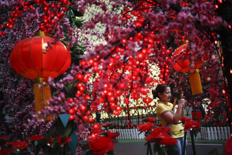 A Malaysian ethnic Chinese woman takes souvenir photographs in front of Lunar New Year decorations in Kuala Lumpur, Malaysia, Friday, Feb. 5, 2016. The Lunar New Year which falls on Feb. 8 this year marks the Year of the Monkey in the Chinese calendar. (AP Photo/Joshua Paul)