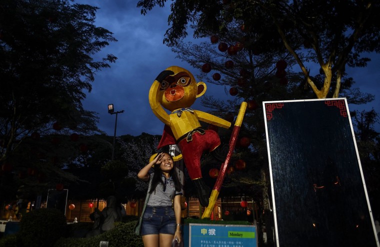 A young ethnic Malaysian-Chinese woman poses with a monkey statue at the Fo Guang Shan Dong Zen temple in Jenjarom, on the outskirts of Kuala Lumpur on February 5, 2016, ahead of the Lunar New Year celebrations. The Lunar New Year will mark the start of the year of the monkey on February 8. (Manan Vatsyayana/AFP/Getty Images)