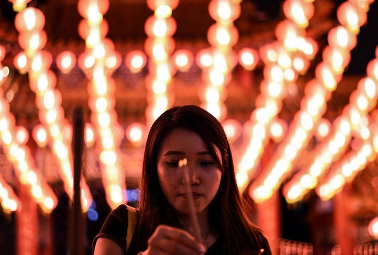 An Ethnic Malaysian-Chinese devotee burns joss-sticks at the Thean Hou temple decorated with red lanterns in Kuala Lumpur on February 7, 2016, on the eve of the Lunar New Year. The Lunar New Year will mark the start of the Year of the Monkey on February 8. (Manan Vatsyayana/AFP/Getty Images)