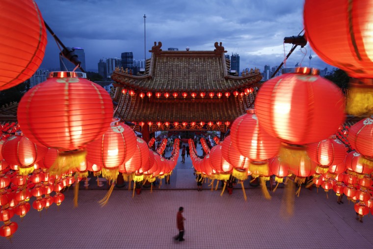 A Malaysian ethnic Chinese man walks under the illuminated traditional Chinese lanterns on the eve of Lunar New Year in Kuala Lumpur, Malaysia, Sunday, Feb. 7, 2016. The Lunar New Year which falls on Feb. 8 this year marks the Year of the Monkey in the Chinese calendar. (AP Photo/Joshua Paul)