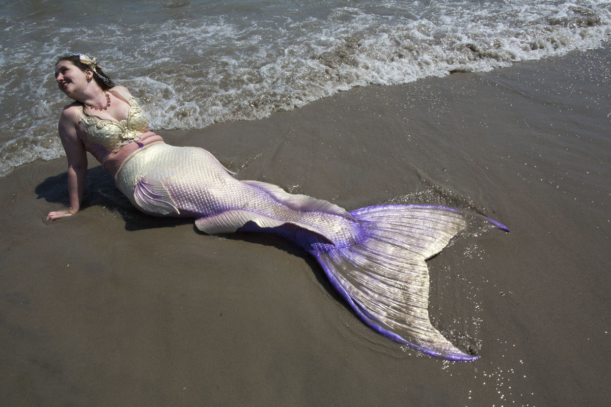 cools off in the ocean after marching in the 34th Annual Mermaid 