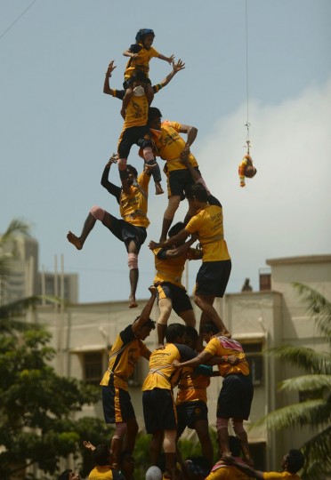 FILE - This file photograph taken on August 29, 2013, shows Indian Hindu devotees collapsing as they try to form a human pyramid to break the dahi-handi, curd-pot, suspended in the air during celebrations of Janmashtami, which marks the birth of Hindu God Lord Krishna, in Mumbai. India's top court on August 17, 2016, has banned children from taking part in a popular but potentially dangerous religious festival in the country's west that sees young boys scale human pyramids. The Supreme Court barred children aged under 18 from scaling the pyramids and restricted their height to 20 feet (six metres) following a string of accidents in recent years. (Punit Paranjpe/AFP/Getty Images)