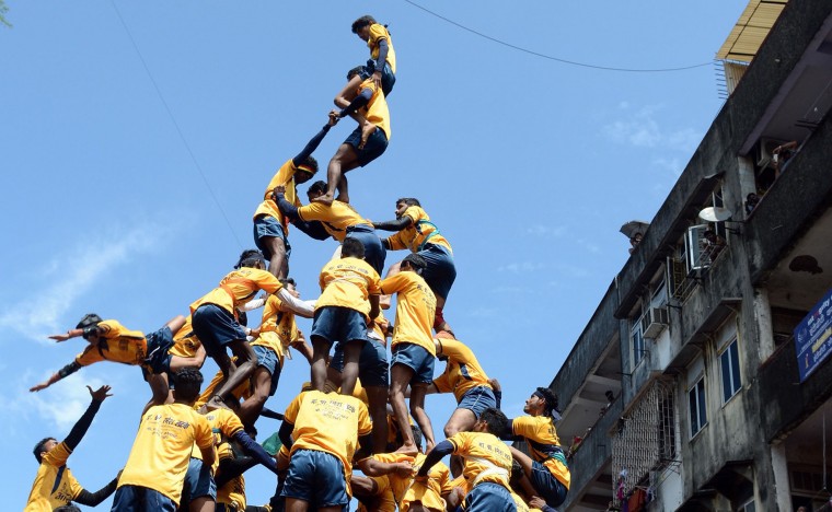 FILE - This file photograph taken on September 6, 2015 shows a Indian Hindu devotee (bottom L) falling during an attempt to form a human pyramid in a bid to reach and break a dahi-handi (curd-pot) suspended in the air during celebrations for the Janmashtami festival, which marks the birth of Hindu God Lord Krishna in Mumbai. India's top court on August 17, 2016, has banned children from taking part in a popular but potentially dangerous religious festival in the country's west that sees young boys scale human pyramids. The Supreme Court barred children aged under 18 from scaling the pyramids and restricted their height to 20 feet (six metres) following a string of accidents in recent years. (Indranil Mukherjee/AFP/Getty Images)