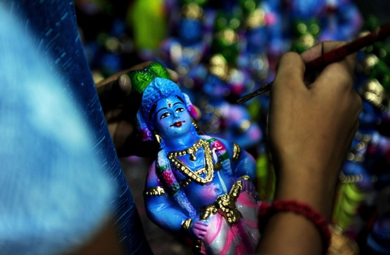 A Indian woman worker gives the finishing touches to an idol of Hindu god Krishna at a workshop on occasion of 'Krishna Janmashtami' in Chennai on August 20, 2016. The birthday of Indian Hindu God Krishna will be celebrated as 'Krishna Janmashtami' by Hindus all over world on August 25. (Arun Sankar/AFP/Getty Images)