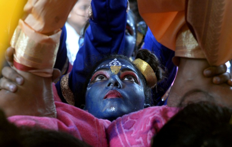 An Indian participant dressed as the Hindu god Lord Krishna helps support others making a 'human pyramid' during a cultural event in the run up to the dahi handi (curd pot) celebrations of 'Janmashtami', which mark the birth of Lord Krishna, in Mumbai on August 23, 2016. India's top court on August 17, 2016, has banned children from taking part in a popular but potentially dangerous religious festival in the country's west that sees young boys scale human pyramids. The Supreme Court barred children aged under 18 from scaling the pyramids and restricted their height to 20 feet (six metres) following a string of accidents in recent years. (Indranil Mukherjee/AFP/Getty Images)