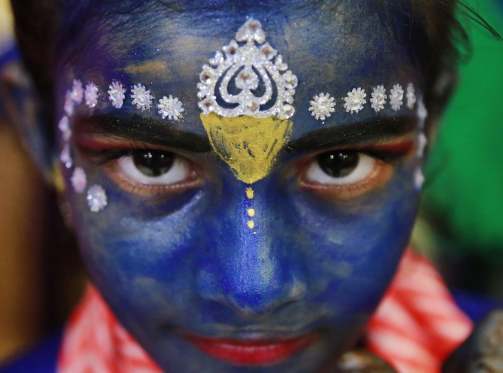 An Indian student who got her face painted with blue color looks at camera ahead of Janmashtami celebrations at a college in Mumbai, India, Tuesday, Aug. 23, 2016. Janmashtami, is an annual celebration of the birth of the Hindu deity Krishna. (AP Photo/Rafiq Maqbool)